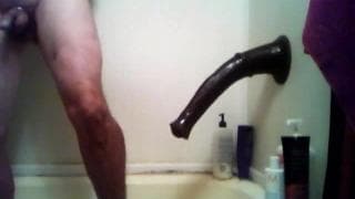 Un uomo gioca in bagno con un cazzo finto