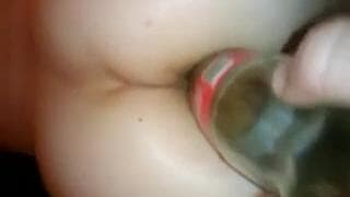 Una bottiglia di vetro per il suo culo