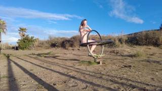 Donna si espone e si masturba all'aperto con un dildo multicolore